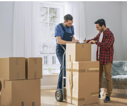 Un professionnel et une personne qui déménage signe un papier. 