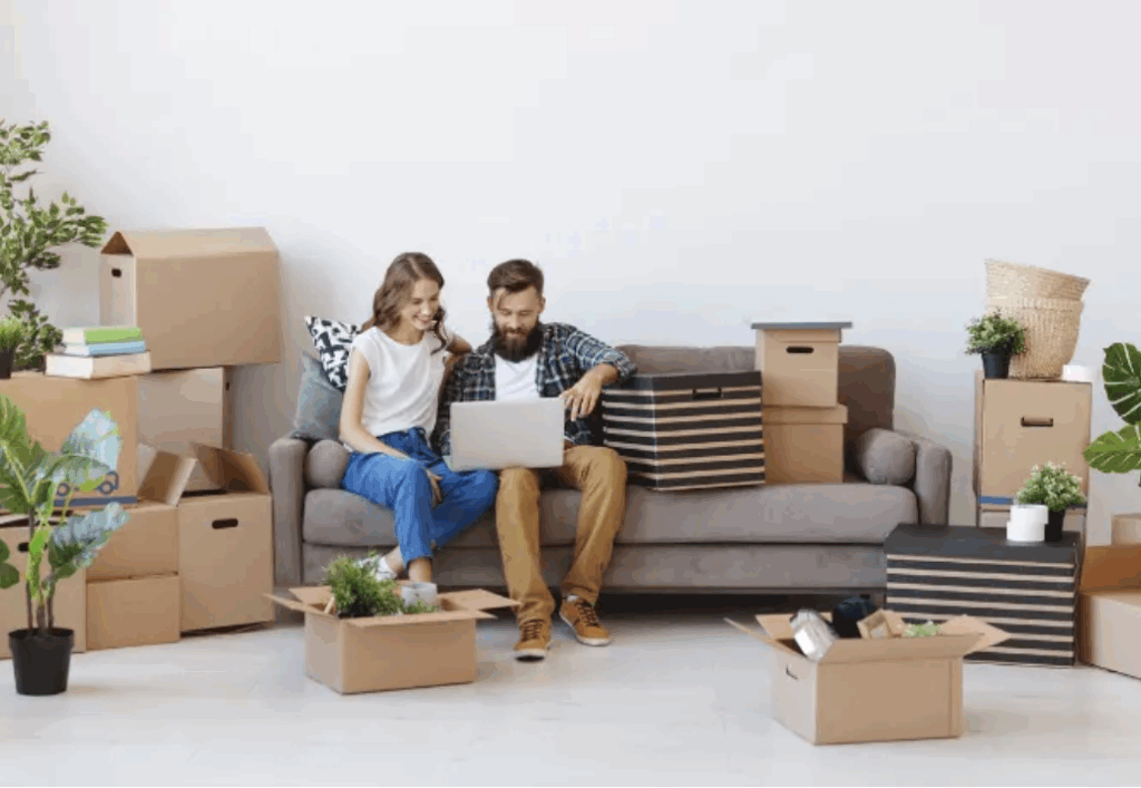 2 personnes assises sur un canapé en plein déménagement